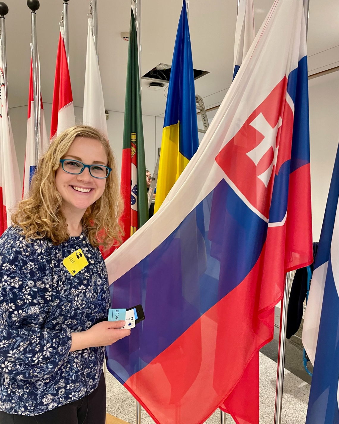 ETA Sadie smiling in front of the Slovakia flag